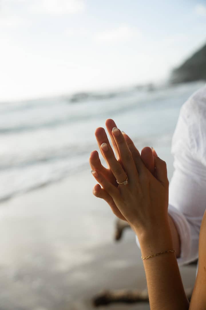 how much should you spend on an engagement ring couple holding hands wearing engagement ring